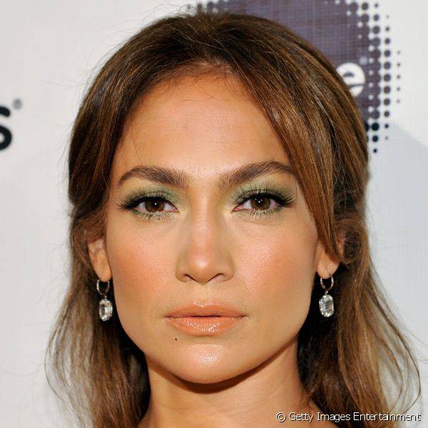 Dona de makes belos, porém neutros, Jennifer Lopez soube incorporar cores de modo suave ao seu look. A cantora e atriz aplicou sombra verde nos olhos, blush bronze e gloss alaranjado.